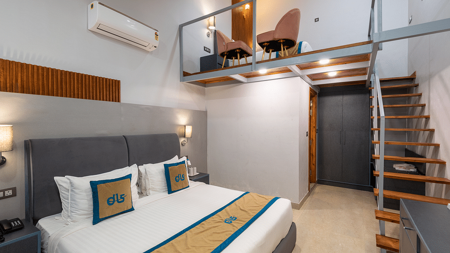 Spring Duplex Room at DLS Spring  Valley resort Dharamshala featuring a king bed table, chairs and stairs leading to second story
